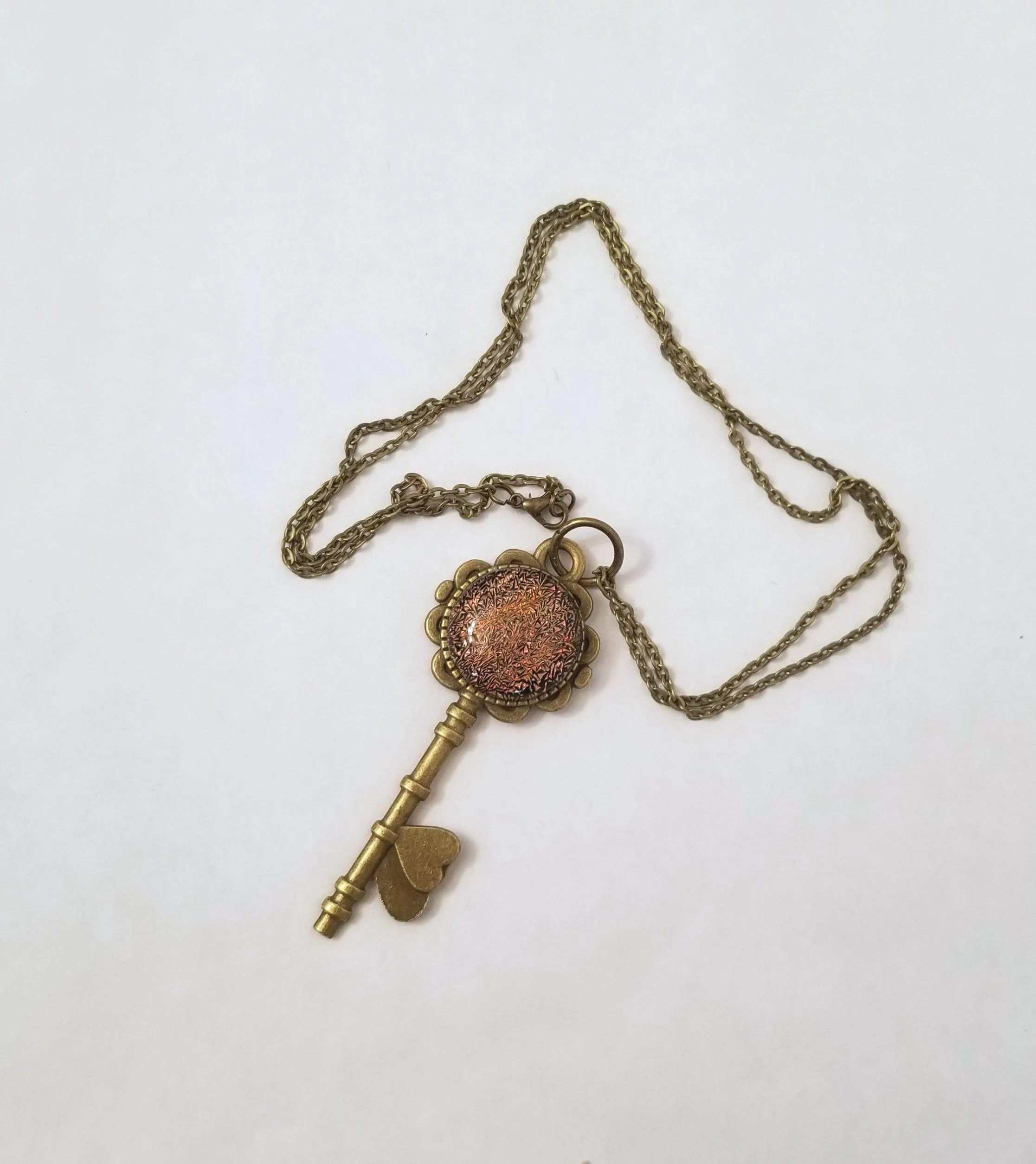 Antiqued Brass Flowered Skeleton Key with Fused Glass Orange Dichroic cabochon on 24 inch brass plated chain