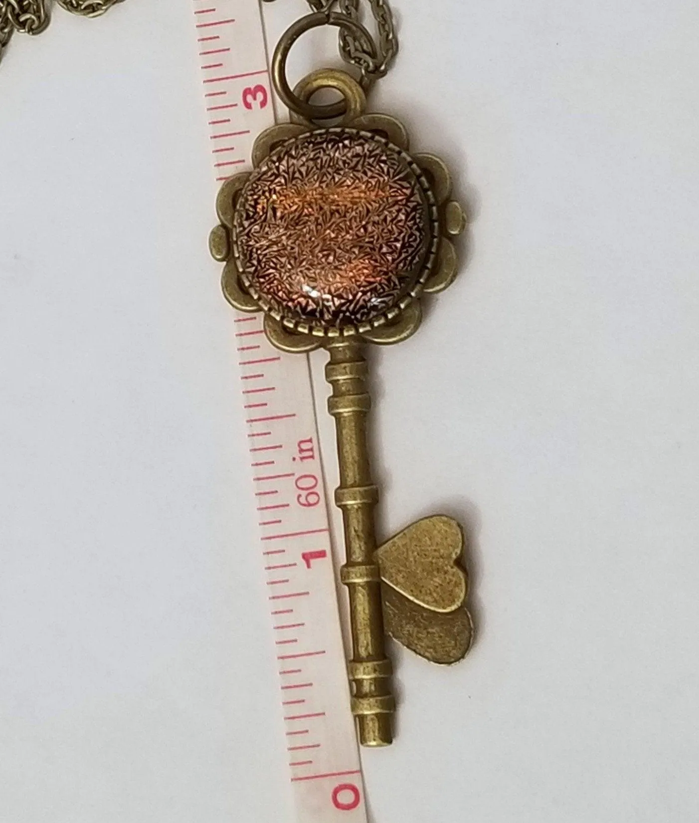 Antiqued Brass Flowered Skeleton Key with Fused Glass Orange Dichroic cabochon on 24 inch brass plated chain
