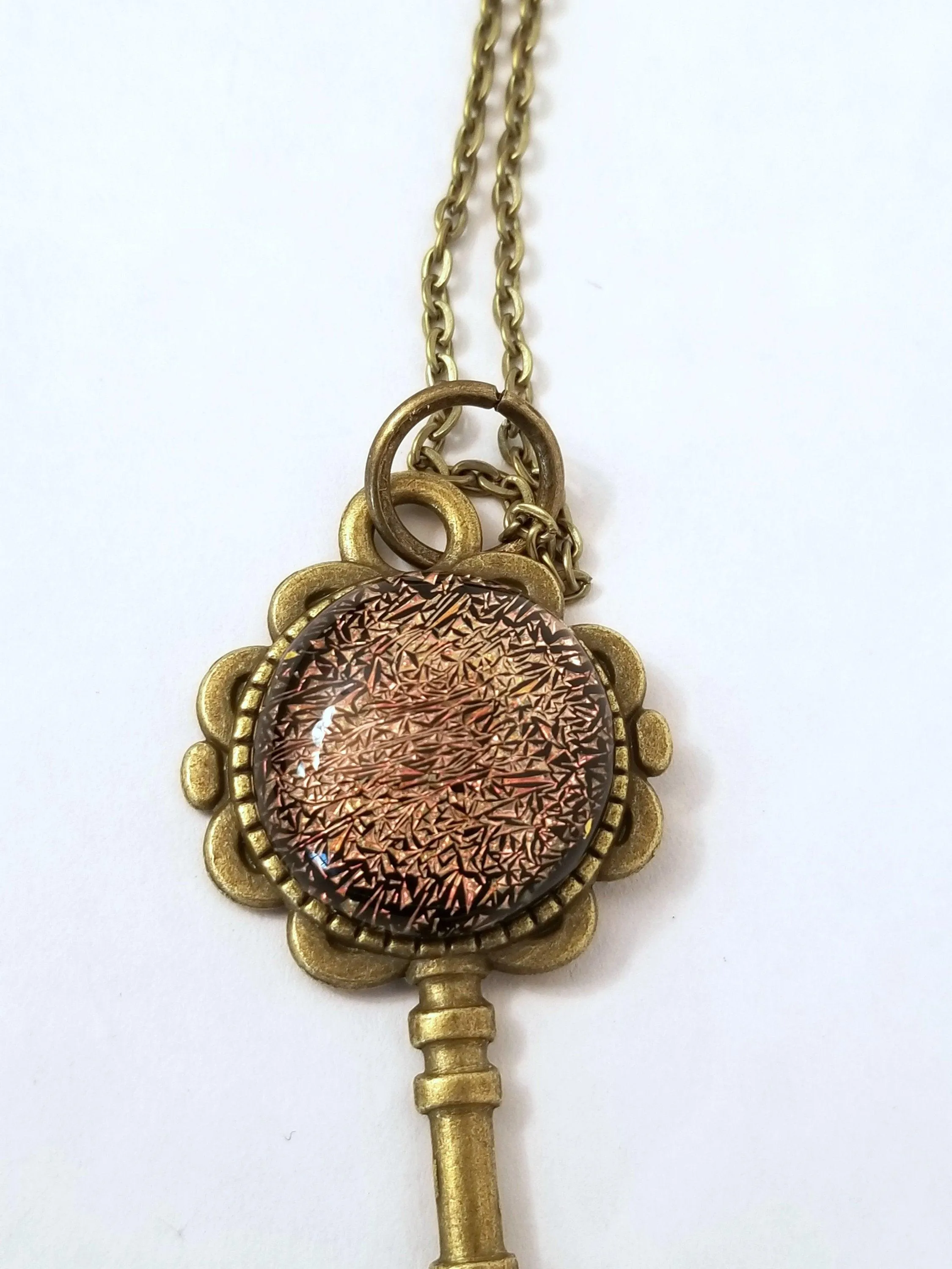 Antiqued Brass Flowered Skeleton Key with Fused Glass Orange Dichroic cabochon on 24 inch brass plated chain